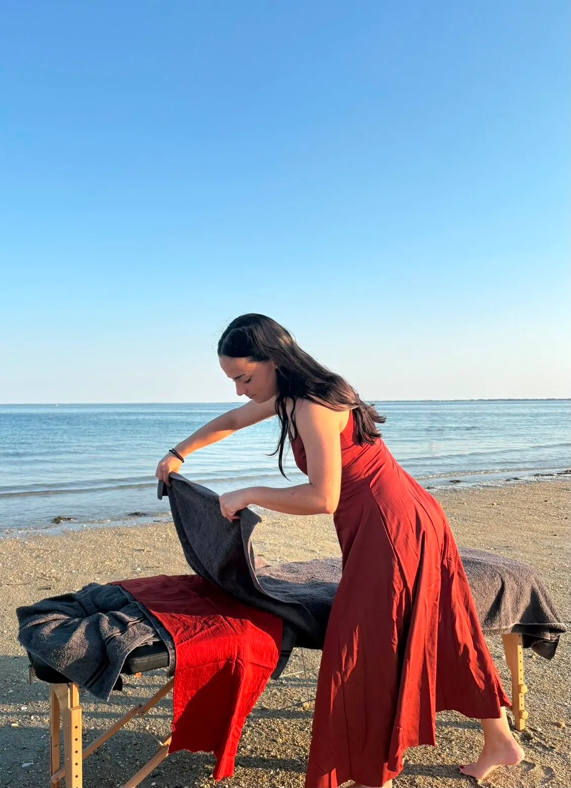 Laura prépare sa table de massage sur la plage